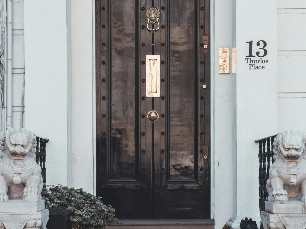 Front door with address numbers and two flanking fu dogs