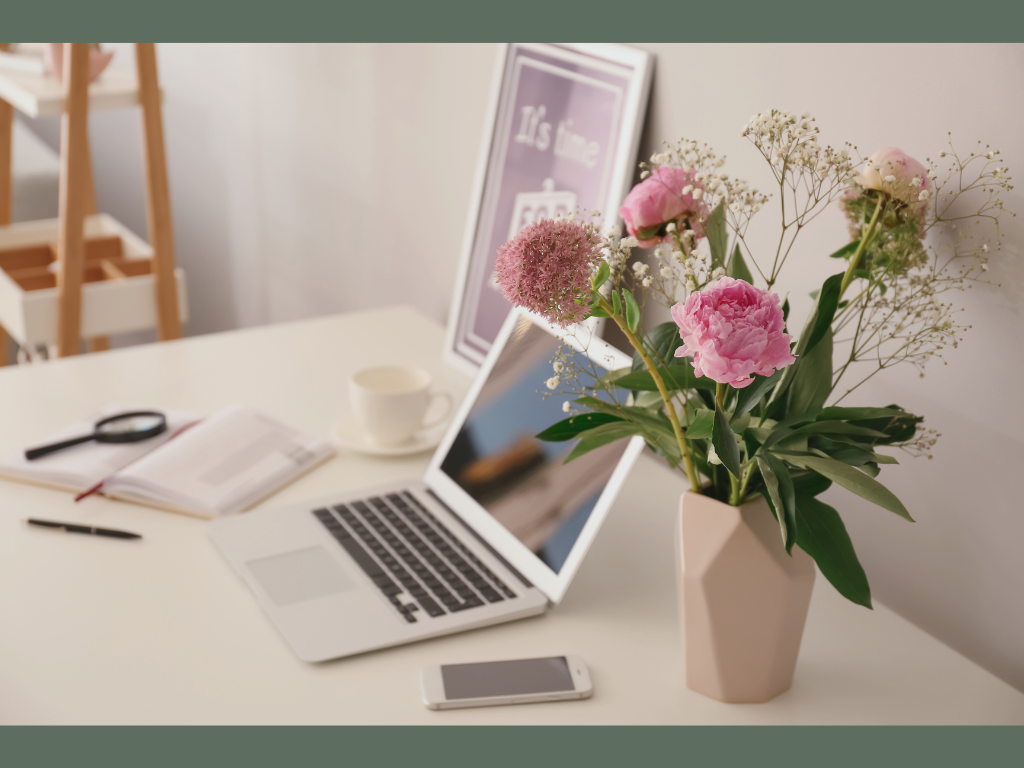 desk with laptop and flowers