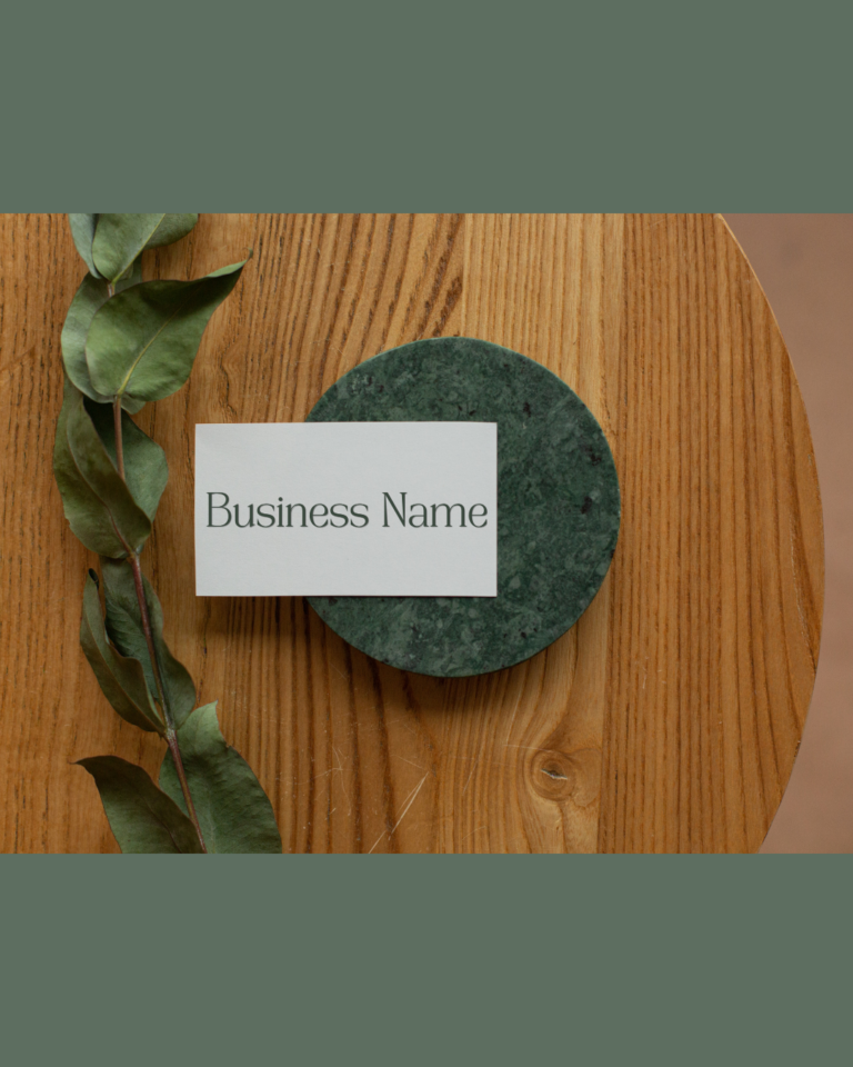desktop with coaster and sprig of eucalyptus and business card
