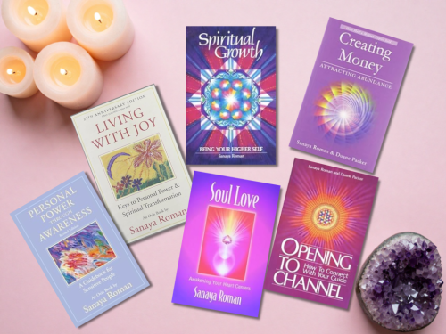 Table top with Sanaya Roman books and candles and an amethyst